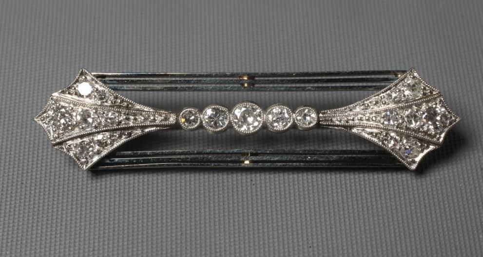 AN ART DECO DIAMOND BROOCH, the open oblong panel with a pave set arrowhead terminal to each end Image