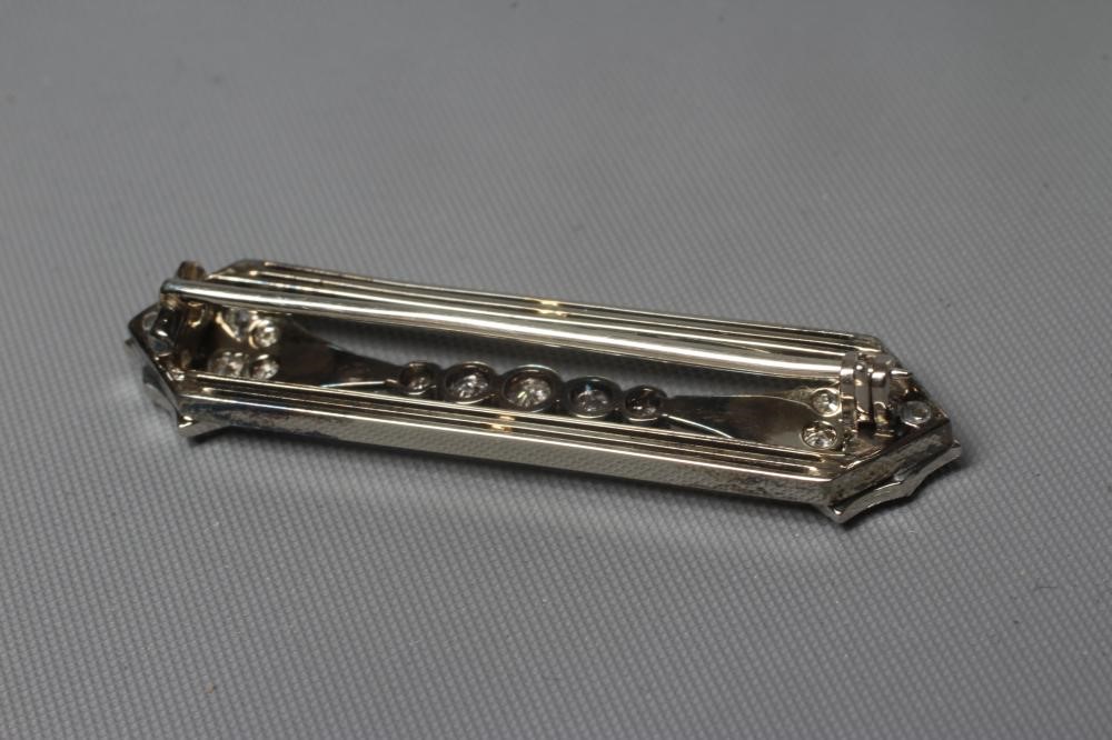AN ART DECO DIAMOND BROOCH, the open oblong panel with a pave set arrowhead terminal to each end Image