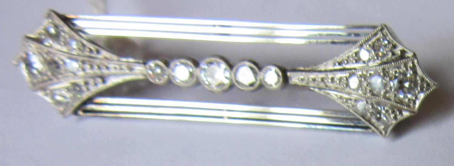AN ART DECO DIAMOND BROOCH, the open oblong panel with a pave set arrowhead terminal to each end Image