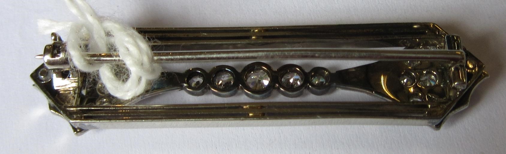 AN ART DECO DIAMOND BROOCH, the open oblong panel with a pave set arrowhead terminal to each end Image