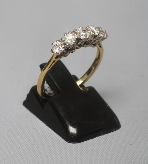 A FIVE STONE DIAMOND RING, the brilliant cut stones claw set to a plain shank stamped 18ct, size M Image