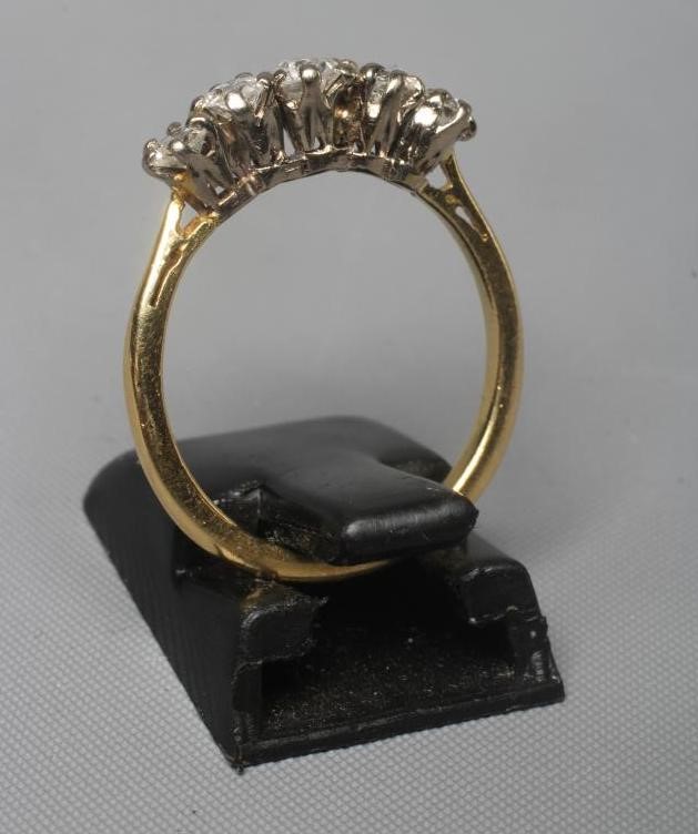 A FIVE STONE DIAMOND RING, the brilliant cut stones claw set to a plain shank stamped 18ct, size M Image