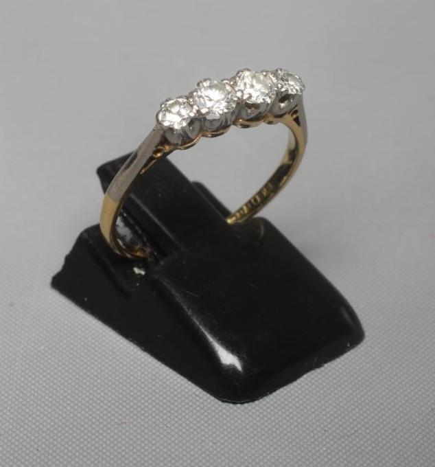 A FOUR STONE DIAMOND RING, the graduating old cut stones totalling approximately 0.50cts claw set to Image