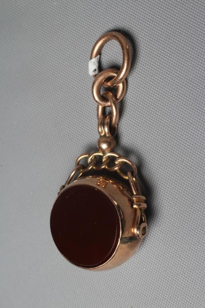 AN EDWARDIAN 9CT GOLD SWIVEL FOB set with a circular polished cornelian and bloodstone, Birmingham Image