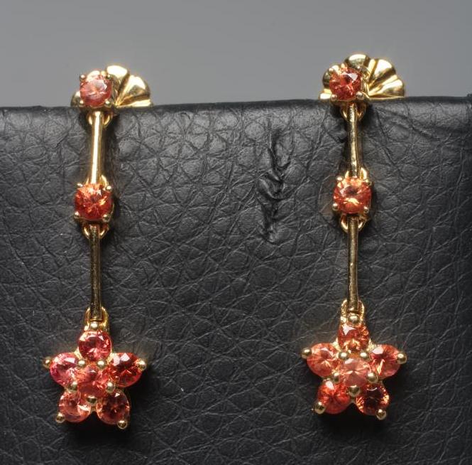 A PAIR OF ORANGE SAPPHIRE DROP EAR STUDS, the six stone cluster fixed to two knife edge bars with a Image