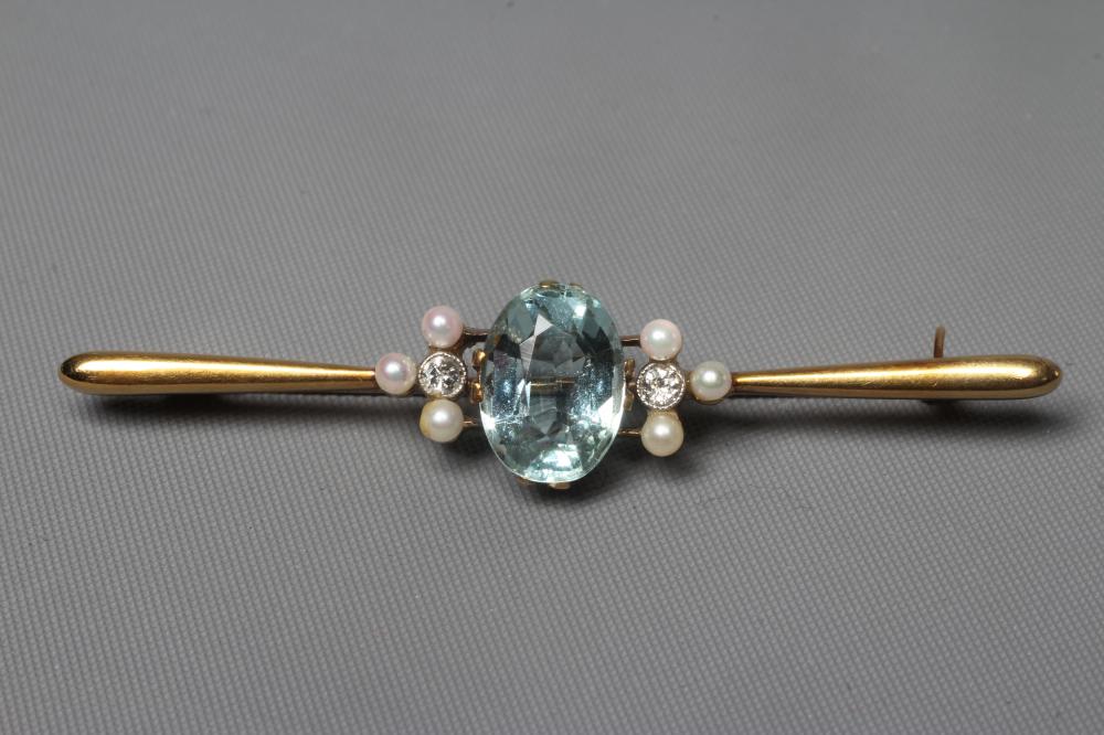 A LATE VICTORIAN PROPELLOR BAR BROOCH centred by an oval facet cut aquamarine flanked by a trefoil Image