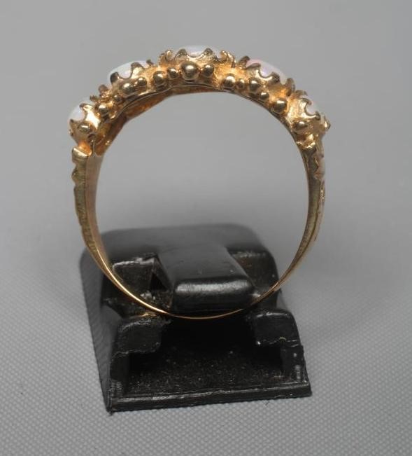 A FIVE STONE OPAL RING, the oval cabochon polished graduating stones claw set to scroll carved Image