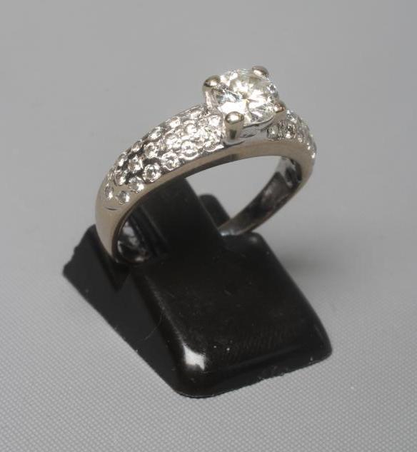 A SOLITAIRE DIAMOND RING, the brilliant cut stone of approximately 0.75cts, claw set to pave set Image