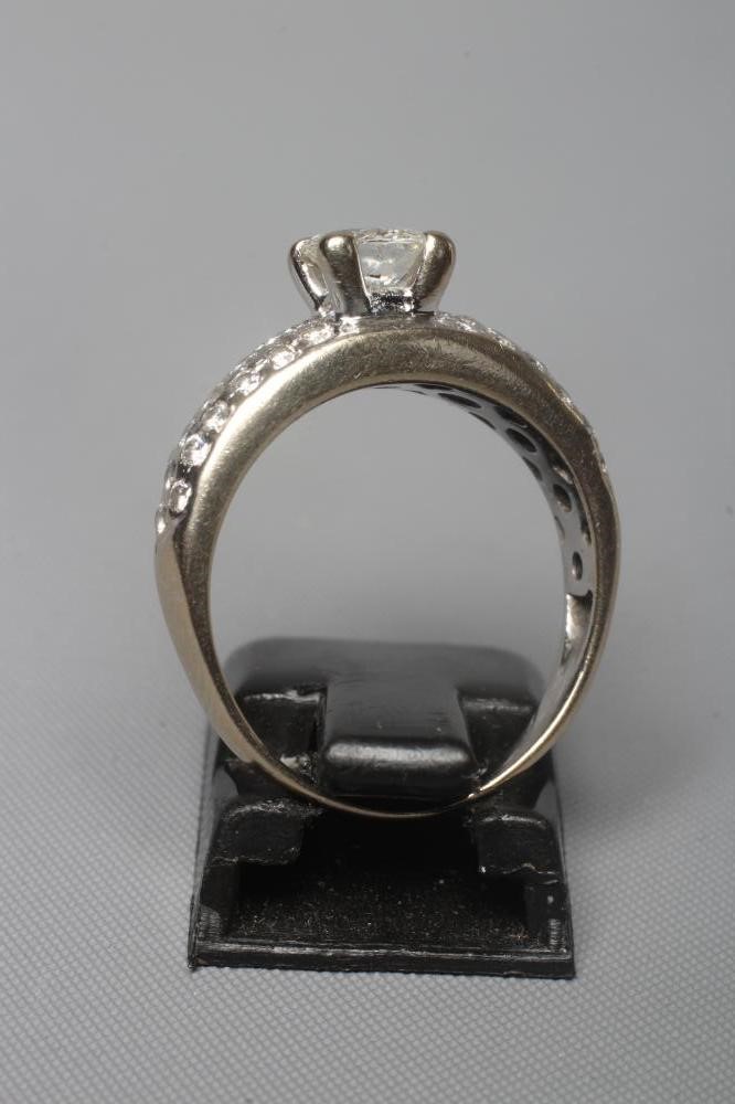 A SOLITAIRE DIAMOND RING, the brilliant cut stone of approximately 0.75cts, claw set to pave set Image