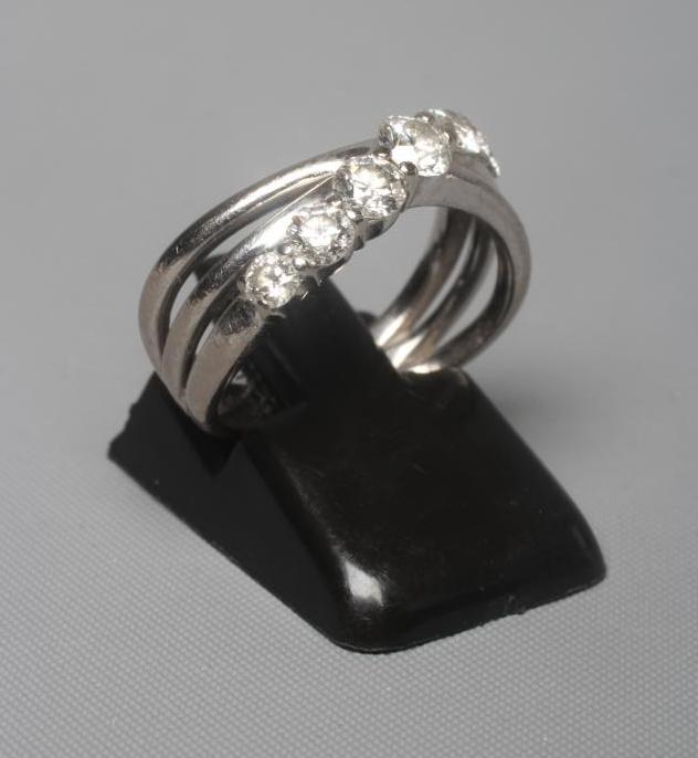 A SEVEN STONE DIAMOND RING, the graduated brilliant cut stones claw set to a triple crossover style Image