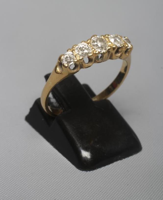 A FIVE STONE DIAMOND RING, the old cut stones claw set to a plain unmarked shank, size Q (Est. plus Image