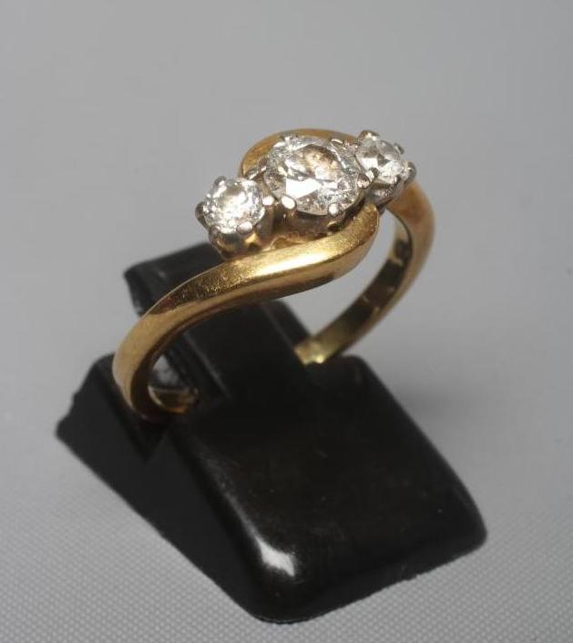 A THREE STONE DIAMOND CROSSOVER RING, the central old brilliant cut stone of approximately 0.5cts, Image