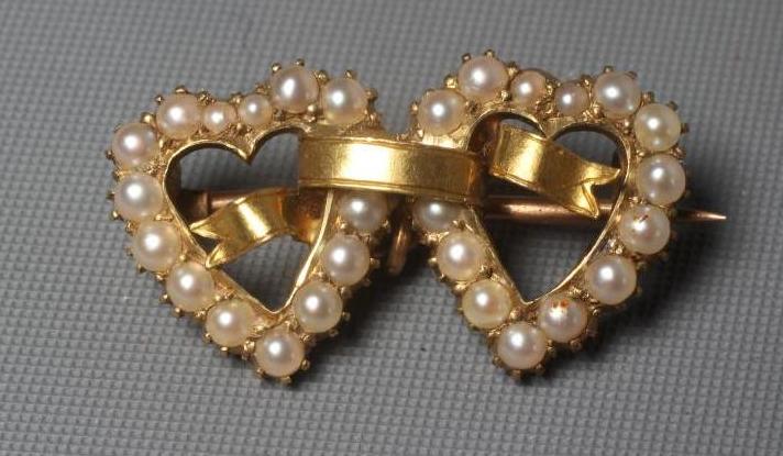 AN EDWARDIAN SWEETHEART SEED PEARL BROOCH, the open double hearts with an un-engraved banner Image