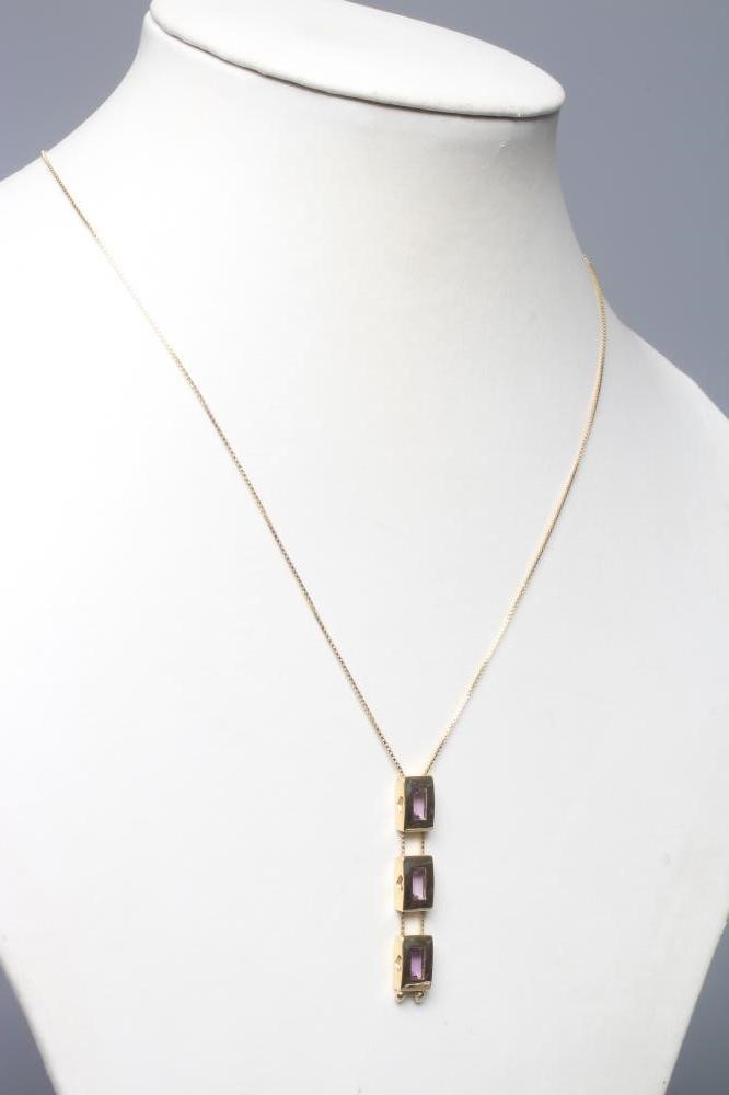 A MODERN AMETHYST PENDANT, the three oblong facet cut stones in plain block rub-over settings fixed Image