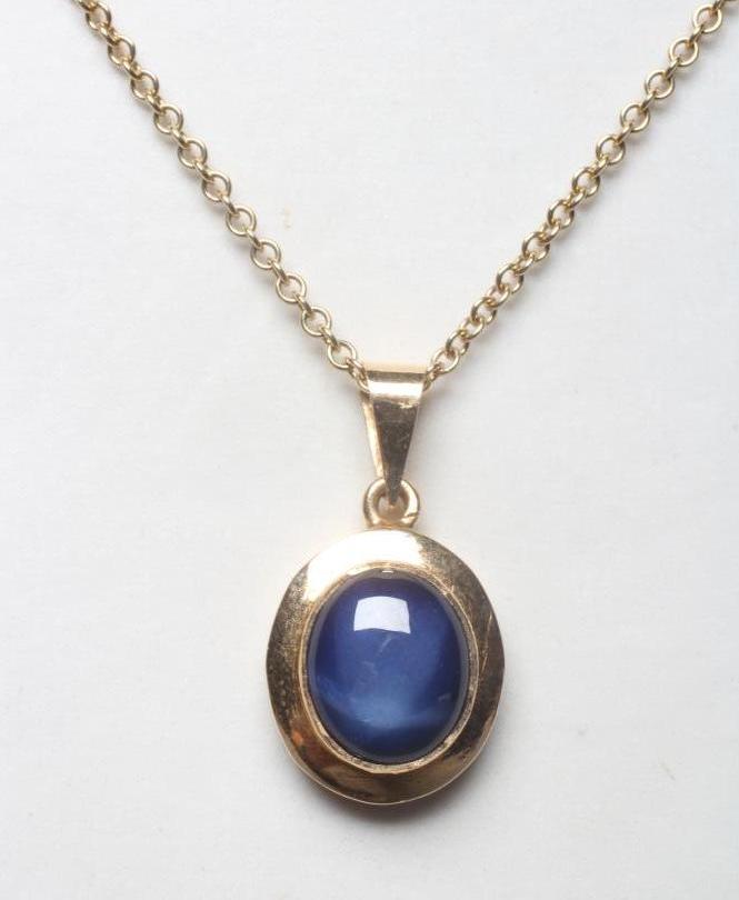A STAR SAPPHIRE PENDANT, the oval stone collet set in a plain swept mount, on a chain necklace with Image