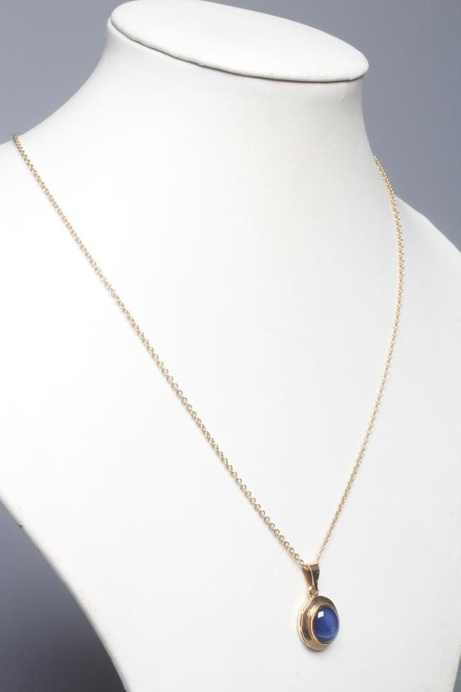 A STAR SAPPHIRE PENDANT, the oval stone collet set in a plain swept mount, on a chain necklace with Image