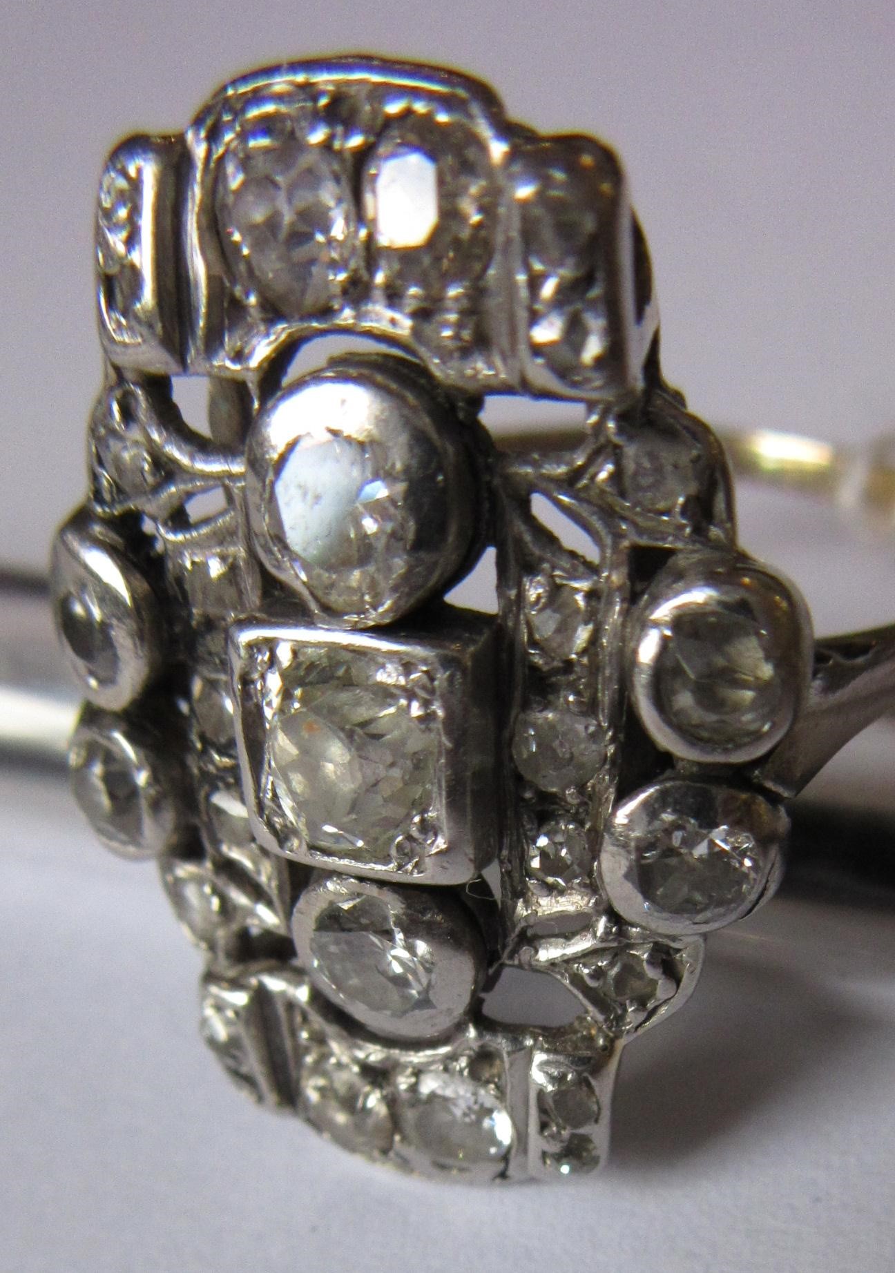 AN ART DECO PLAQUE RING, the numerous mix cut stones in rub-over and claw settings to a plain 18ct Image