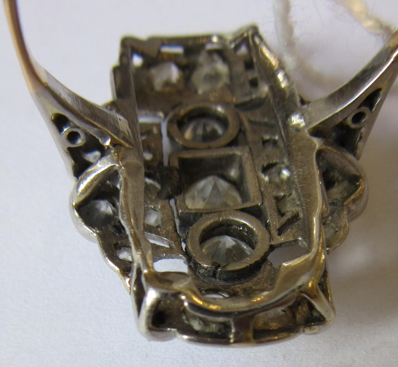 AN ART DECO PLAQUE RING, the numerous mix cut stones in rub-over and claw settings to a plain 18ct Image