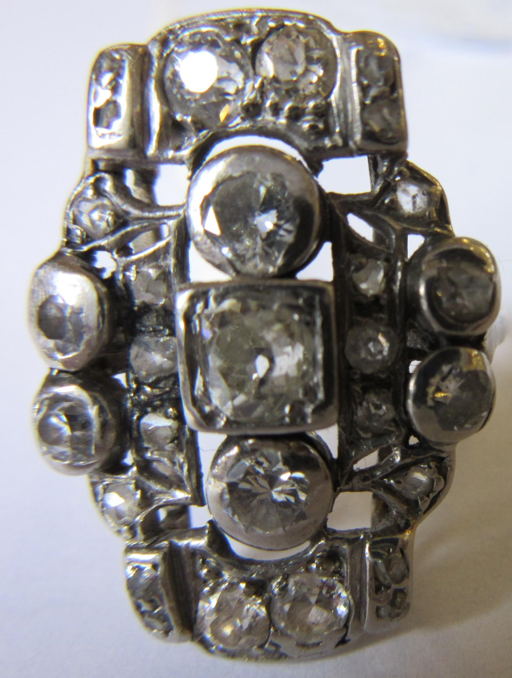 AN ART DECO PLAQUE RING, the numerous mix cut stones in rub-over and claw settings to a plain 18ct Image