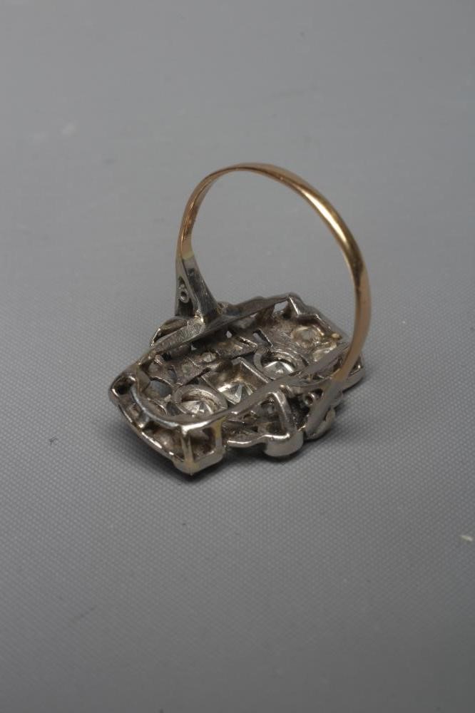 AN ART DECO PLAQUE RING, the numerous mix cut stones in rub-over and claw settings to a plain 18ct Image