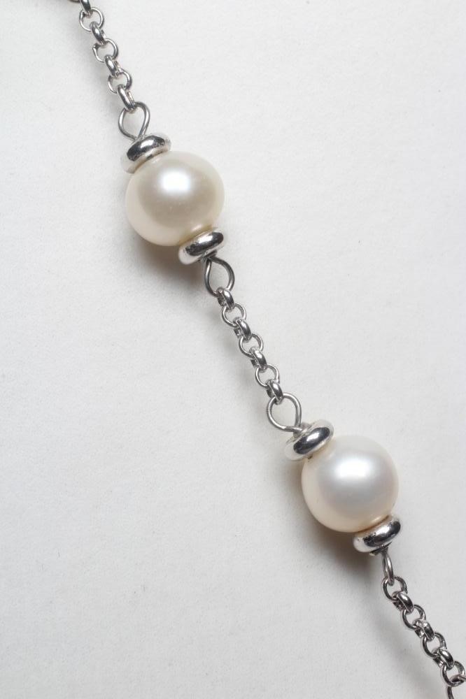 A CULTURED PEARL NECKLACE, the twenty white pearls on a white chain with lobster clasp stamped 750 Image