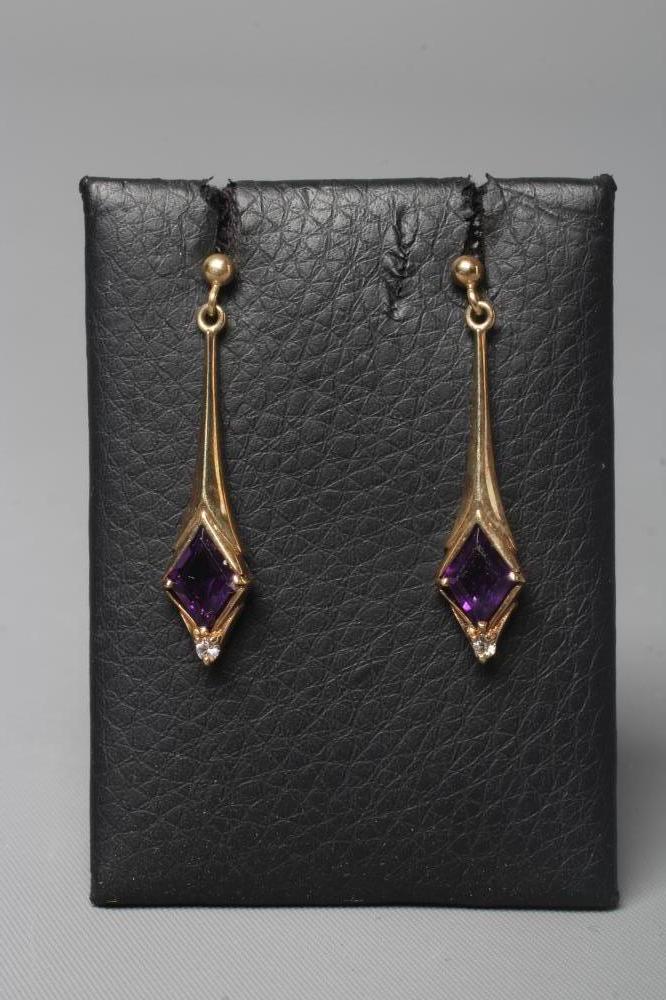 A PAIR OF AMETHYST DROP EARRINGS, the lozenge facet cut stones set above a diamond point below a 9ct Image