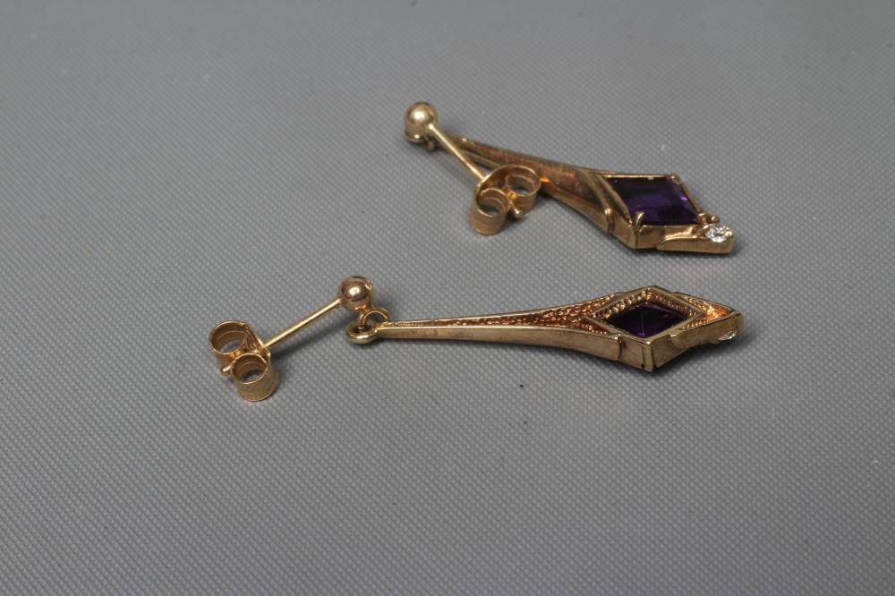 A PAIR OF AMETHYST DROP EARRINGS, the lozenge facet cut stones set above a diamond point below a 9ct Image