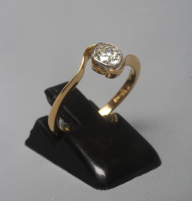 A SOLITAIRE DIAMOND RING, the old cut stone of approximately 0.5cts in a cross over setting to a Image