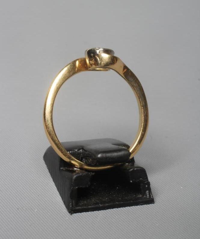 A SOLITAIRE DIAMOND RING, the old cut stone of approximately 0.5cts in a cross over setting to a Image