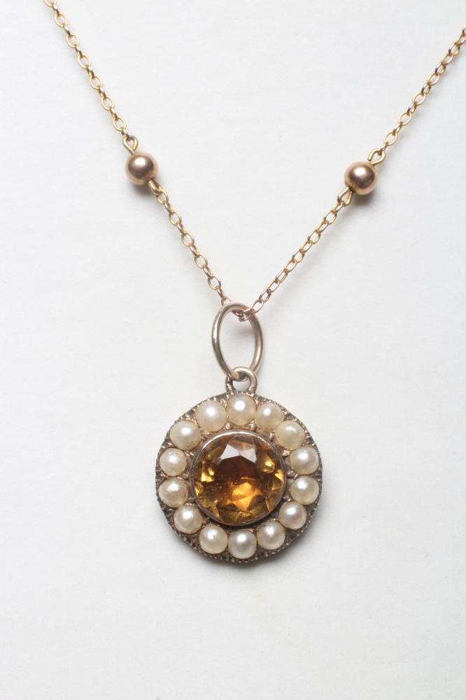 AN EDWARDIAN CITRINE AND SEED PEARL PENDANT, the circular facet cut citrine collet set to a border Image
