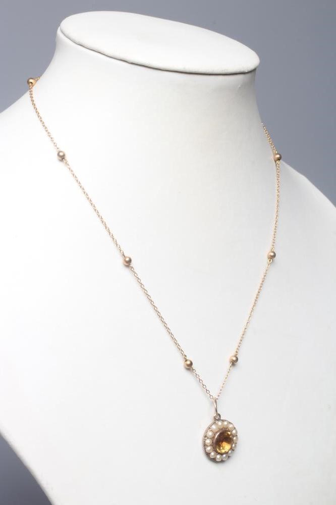 AN EDWARDIAN CITRINE AND SEED PEARL PENDANT, the circular facet cut citrine collet set to a border Image