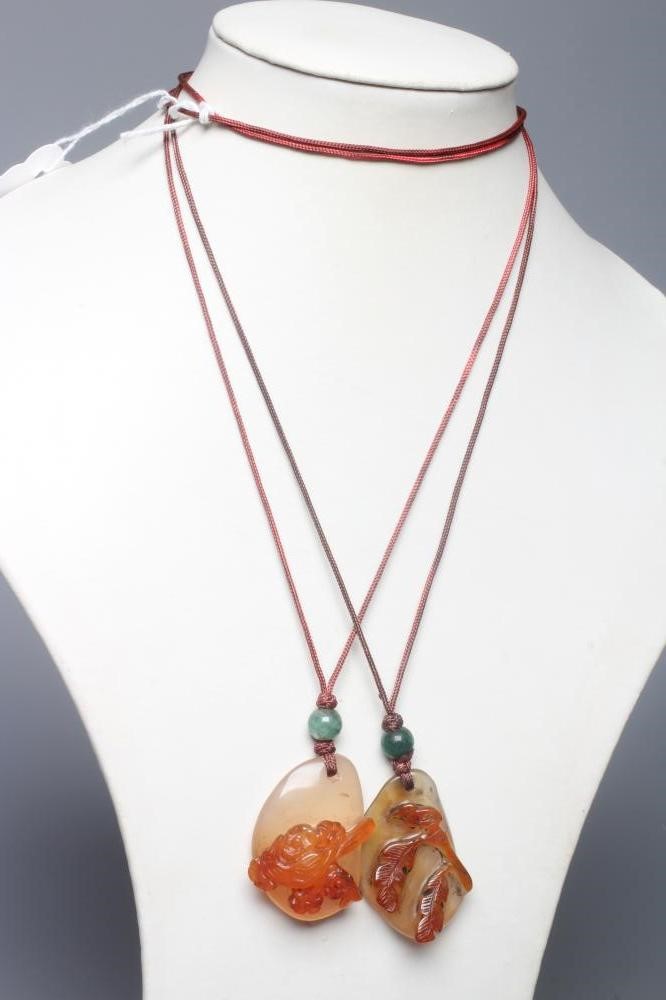 TWO CHINESE CARVED HARDSTONE PENDANTS on silk cords with aventurine bead 'ojime' (Est. plus 24% Image