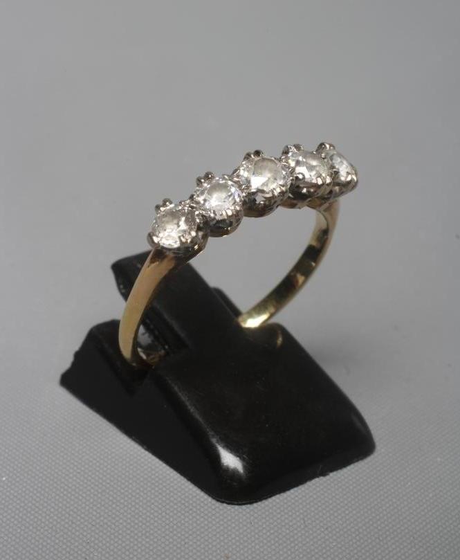 A FIVE STONE DIAMOND RING, the old cut stones each of approximately 0.20cts, claw set to plain Image