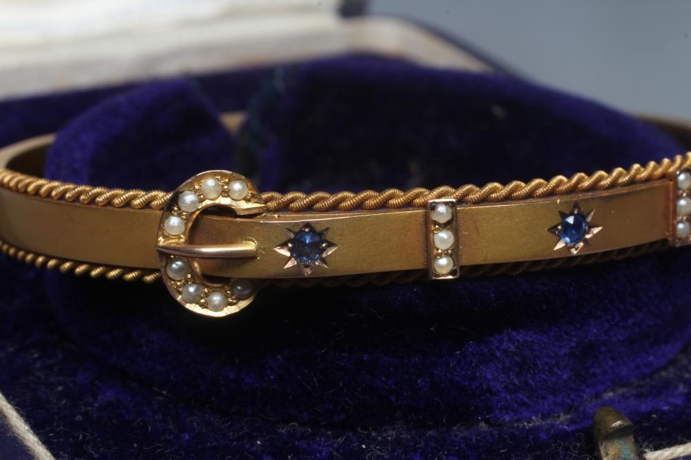 AN EDWARDIAN 9CT GOLD STIFF HINGED BANGLE Image