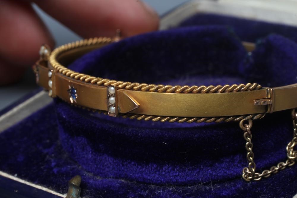 AN EDWARDIAN 9CT GOLD STIFF HINGED BANGLE Image