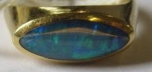 A BLACK OPAL RING, the eliptical polished stone in a rub-over setting to a plain 18ct gold shank, Image