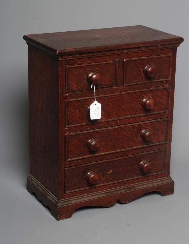 A MINIATURE OAK CHEST OF DRAWERS Image
