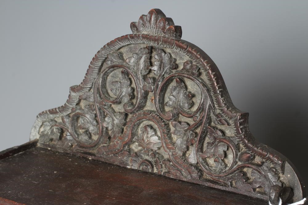 AN EASTERN HARDWOOD APPLIQUE intricately carved with a half length grimacing male figure over a Image
