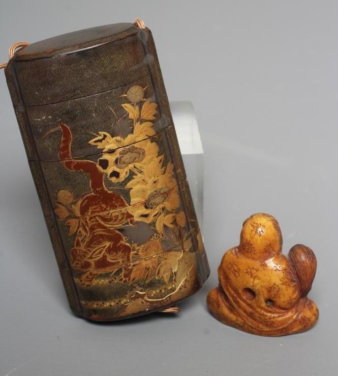A JAPANESE LACQUER FOUR CASE INRO with two Temple Dogs in landscape on a dark green ground Image