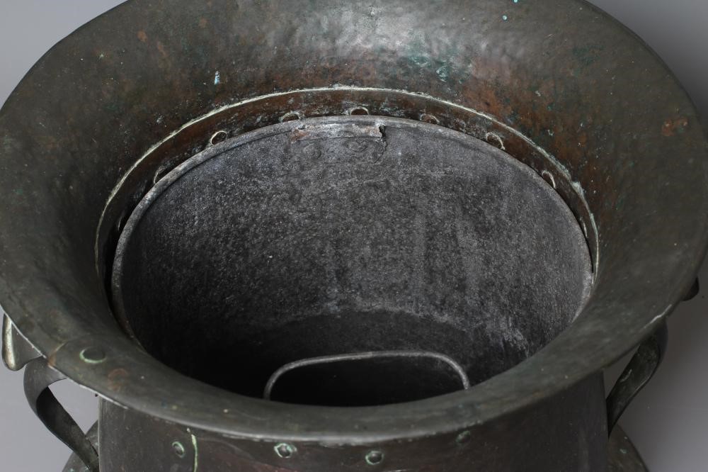 AN ART NOUVEAU COPPER TWO HANDLED COAL BIN AND COVER of swept cylindrical form with repousse Image