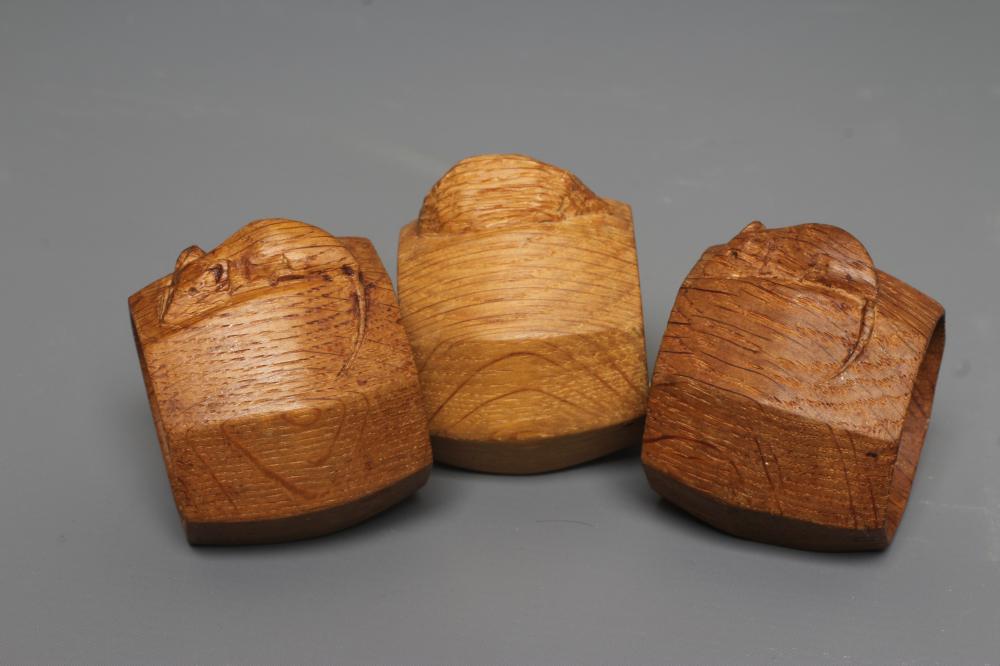 TWO ROBERT THOMPSON OAK OCTAGONAL NAPKIN RINGS each with carved mouse trademark, approximately 2" Image