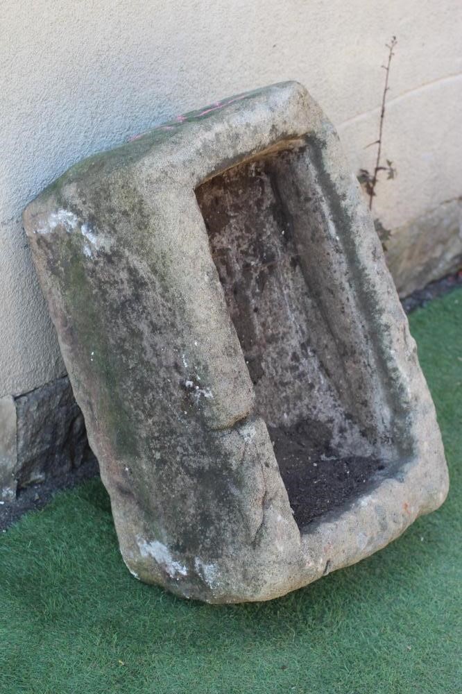 A SANDSTONE TROUGH of rough-hewn oblong form mildly tapering towards the front, 30" w x 19 1/2" d x Image