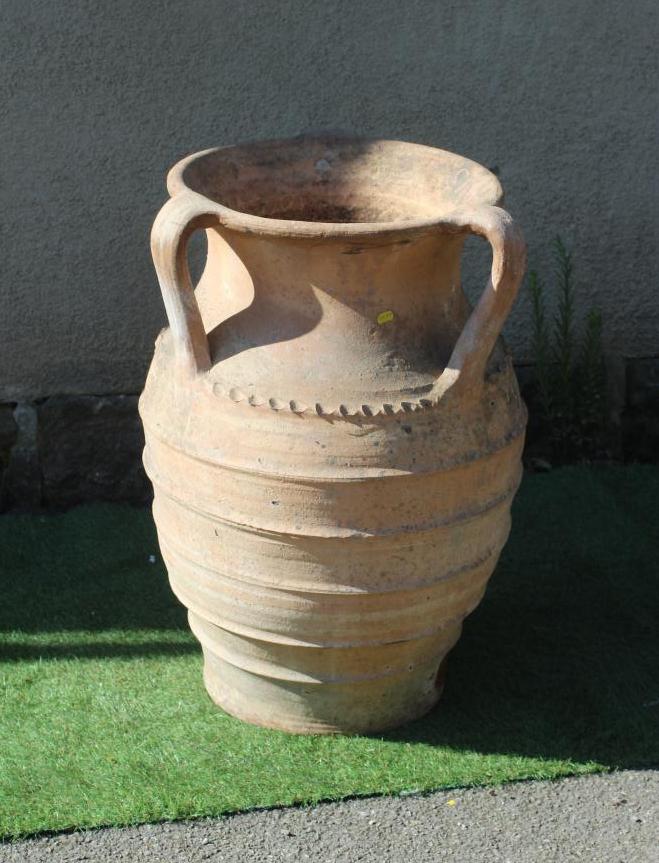 A TERRACOTTA THREE HANDLED VASE with flared rim, the ovoid body with cable twist and ribbed banding, Image