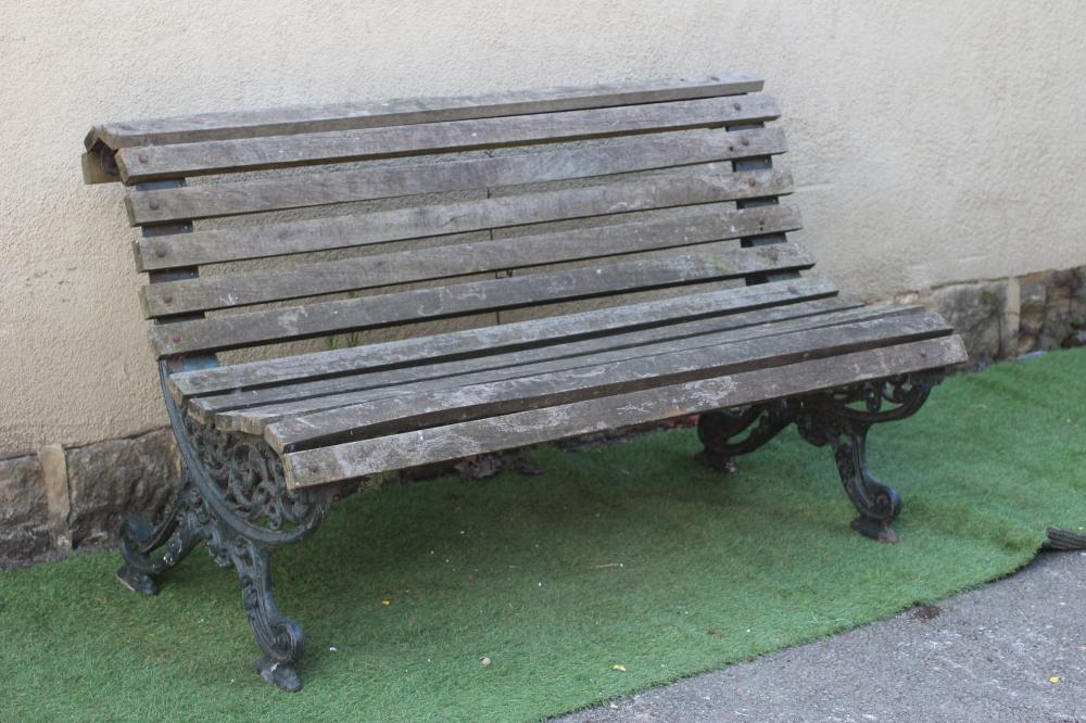 A VICTORIAN CAST IRON PARK BENCH of scrolled outline, the slatted wood seat and back on pierced Image