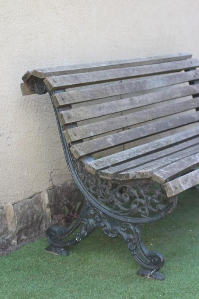 A VICTORIAN CAST IRON PARK BENCH of scrolled outline, the slatted wood seat and back on pierced Image