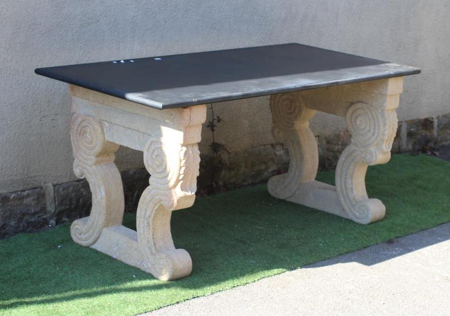 A BLACK GRANITE SIDE TABLE, modern, the oblong polished top on pierced composition sandstone end Image