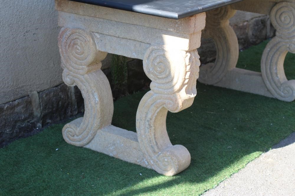 A BLACK GRANITE SIDE TABLE, modern, the oblong polished top on pierced composition sandstone end Image