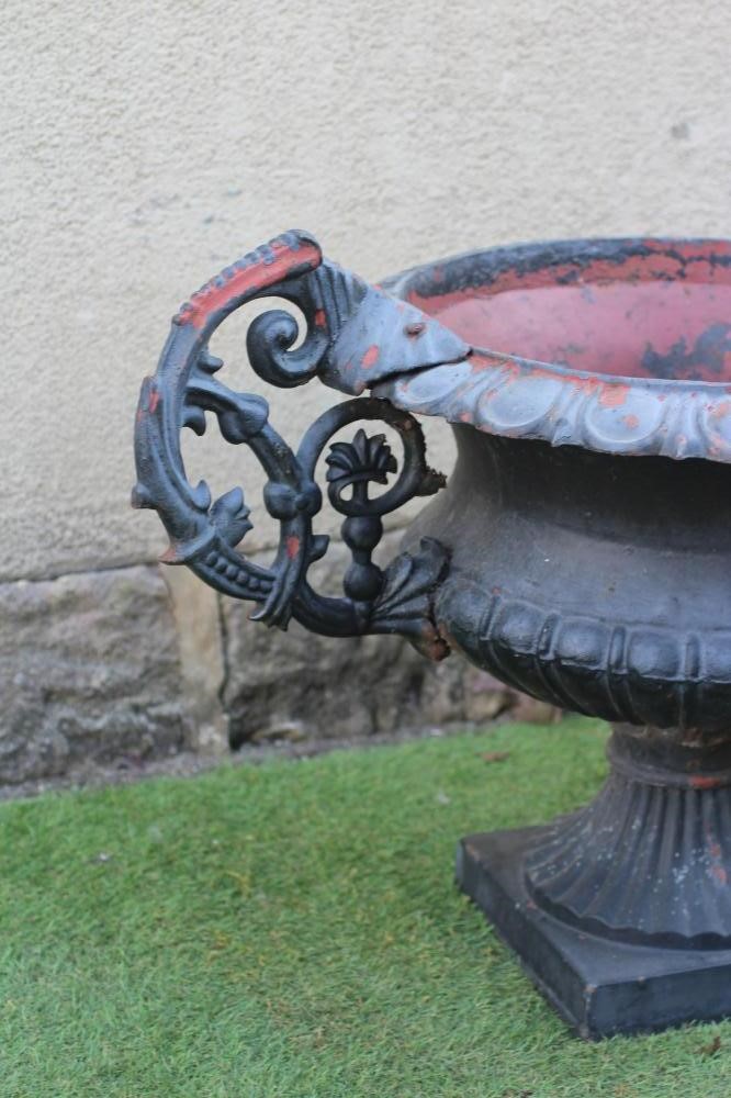 A PAIR OF CAST IRON URNS, 20th century, of semi fluted campana form with scrolled handles and ovolo Image