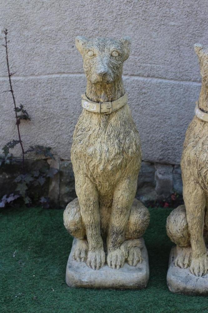 A PAIR OF CAST STONE LURCHER TYPE DOGS modelled seated, with alert expression and wearing a collar, Image