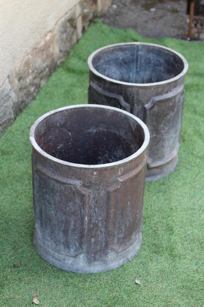 A PAIR OF WEATHERED LEAD CYLINDRICAL PLANTERS, the sides cast with outline cut corner panels, 13 Image